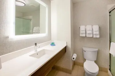 a bathroom with a sink and a toilet and a mirror at Holiday Inn Express Madera by IHG in Madera