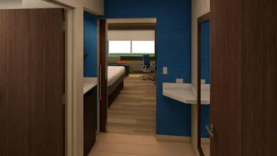 a room with a bedroom with a bed and a desk at Holiday Inn Express Madera by IHG in Madera
