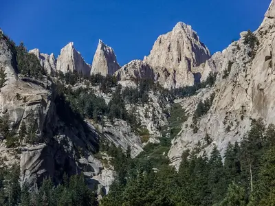a mountain range with tall rocks and trees at Starlight Motel in Big Pine