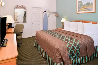 a hotel room with a bed and a desk at Americas Best Value Inn Los Banos in Los Banos