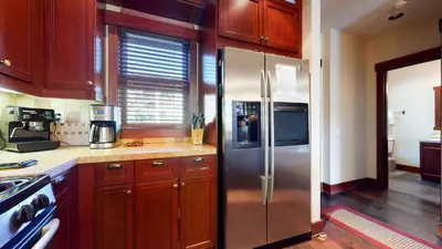a kitchen with a stainless steel refrigerator and wooden cabinets at Juniper Crest 1 Apartment in Mammoth Lakes