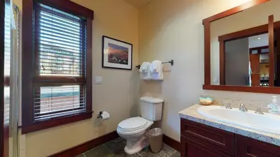 a bathroom with a toilet and a sink and a mirror at Juniper Crest 1 Apartment in Mammoth Lakes