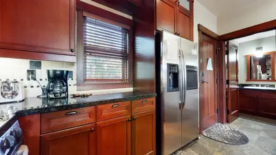 a kitchen with wooden cabinets and a stainless steel refrigerator at Juniper Crest 6 Apartment in Mammoth Lakes