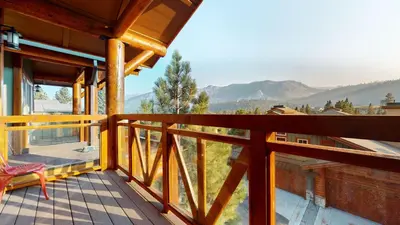 a balcony with a chair and a view of the mountains at Juniper Crest 6 Apartment in Mammoth Lakes