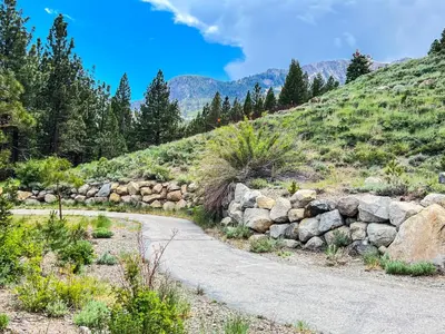 a stone wall next to a mountain road at Juniper Crest 6 Apartment in Mammoth Lakes