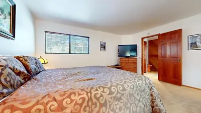 a bedroom with a bed and a flat screen tv at Mammoth Reservations in Mammoth Lakes