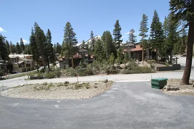 an empty street with houses and trees in the background at Mammoth Reservations in Mammoth Lakes