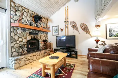 a living room with a large stone fireplace at Mammoth Reservations in Mammoth Lakes