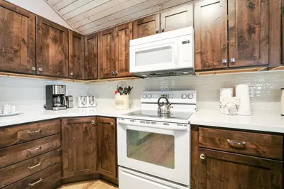 a kitchen with wooden cabinets and a white stove top oven at Mammoth Reservations in Mammoth Lakes