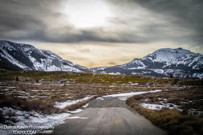 a dirt road with snow capped mountains in the distance at Snowcreek 253 Apartment in Mammoth Lakes