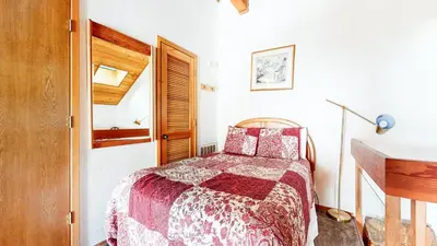 a bedroom with a bed with a red and white comforter at Snowcreek 638 Apartment in Old Mammoth