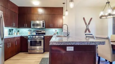 a kitchen with wooden cabinets and stainless steel appliances at Solstice 10 Apartment in Mammoth Lakes