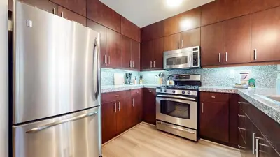 a kitchen with wooden cabinets and a stainless steel refrigerator at Solstice 10 Apartment in Mammoth Lakes