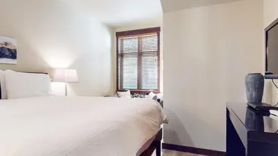 a white bedroom with a bed and a window at Solstice 10 Apartment in Mammoth Lakes