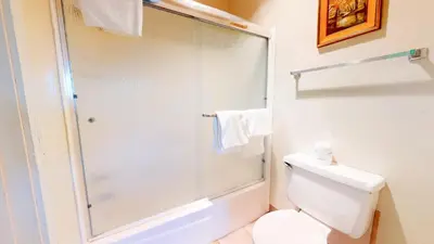 a bathroom with a toilet and a glass shower at Summit 34 Apartment in Mammoth Lakes