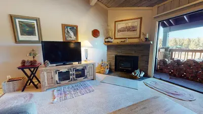 a living room with a television and a fireplace at Summit 34 Apartment in Mammoth Lakes