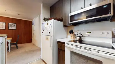 a kitchen with a white stove and a refrigerator at Summit 45 Apartment in Mammoth Lakes