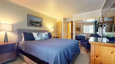 a bedroom with a bed with a blue bedspread at Summit 55 Apartment in Mammoth Lakes