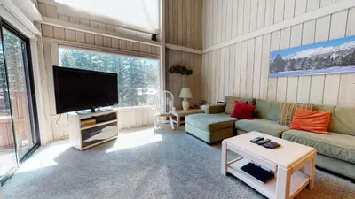a living room with a couch and a tv at Mammoth Reservations in Mammoth Lakes
