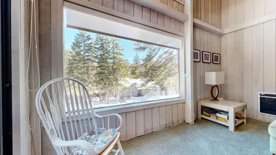a white chair in a room with a window at Mammoth Reservations in Mammoth Lakes