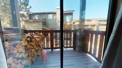 a balcony with a pile of fire wood at Summit 110 Apartment in Mammoth Lakes