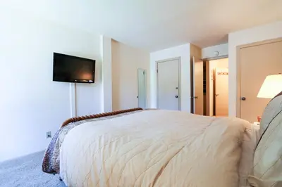a bedroom with a bed and a flat screen tv at Summit 211 Apartment in Mammoth Lakes