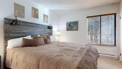 a bedroom with a large bed with a wooden headboard at Rustic Summit 237 On Free Shuttle Route in Mammoth Lakes