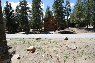 a yard with rocks and a house in the background at Rustic Summit 237 On Free Shuttle Route in Mammoth Lakes