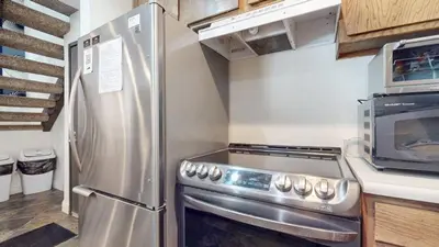 a kitchen with a stainless steel refrigerator and a microwave at Mammoth Reservations in Mammoth Lakes