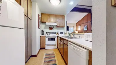 a kitchen with white appliances and wooden cabinets at Mammoth Reservations in Mammoth Lakes
