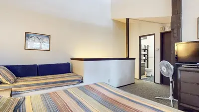 a hotel room with a bed and a flat screen tv at Mammoth Reservations in Mammoth Lakes