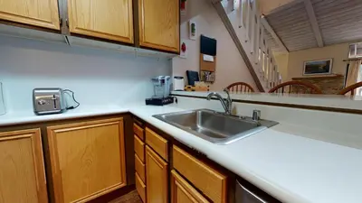 a kitchen with a sink and wooden cabinets at Mammoth Reservations in Mammoth Lakes