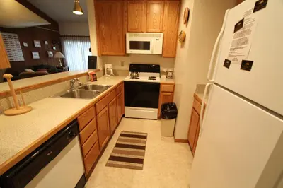 a kitchen with a white refrigerator and a sink at Mammoth Reservations in Mammoth Lakes