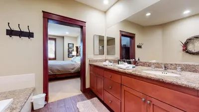 a bathroom with a double sink and a bedroom at Timbers 1 Apartment in Mammoth Lakes