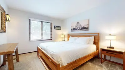 a bedroom with a bed and a desk and a window at Wild Flower 37 Apartment in Mammoth Lakes