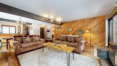a living room with two couches and a table at Wild Flower 39 Apartment in Mammoth Lakes
