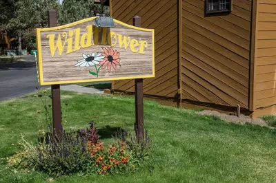 a sign for a wildflower sign in the grass at Wild Flower 39 Apartment in Mammoth Lakes