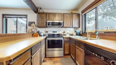 a kitchen with wooden cabinets and a stove top oven at Wild Flower 39 Apartment in Mammoth Lakes