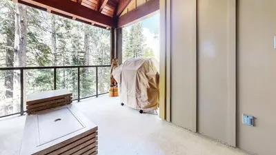 a screened in porch with a view of the woods at Mammoth Reservations in Mammoth Lakes