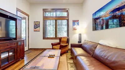 a living room with a leather couch and a television at Mammoth Reservations in Mammoth Lakes