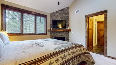 a bedroom with a large bed and a fireplace at Mammoth Reservations in Mammoth Lakes
