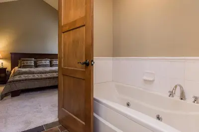 a bathroom with a bath tub next to a bed at Mammoth Reservations in Mammoth Lakes
