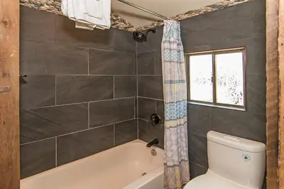 a bathroom with a tub and a toilet and a window at Miner's Camp in Foresthill