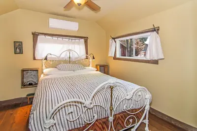a bedroom with a white bed with a window at Miner's Camp in Foresthill
