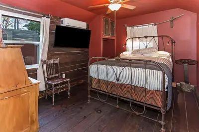a bedroom with an old fashioned bed and a chair at Miner's Camp in Foresthill