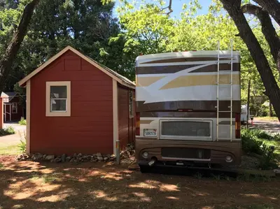a truck parked next to a red shed at Miner's Camp in Foresthill
