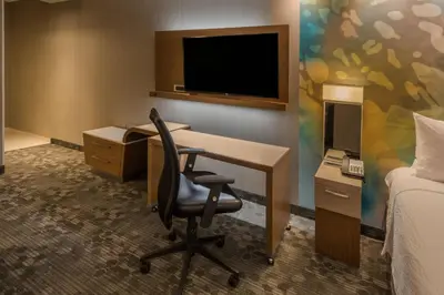 a hotel room with a desk with a computer and a tv at Courtyard by Marriott Reno Downtown/Riverfront in Reno