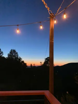 a group of lights hanging from a pole at night at Priest Station Cafe & Cabins in Groveland