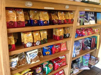 a shelf filled with different types of chips and snacks at Priest Station Cafe & Cabins in Groveland
