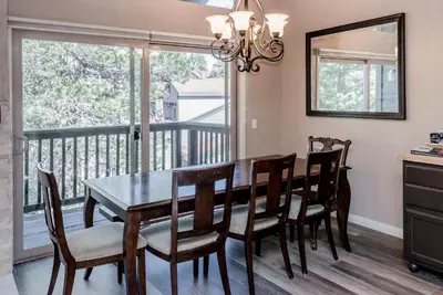 a dining room with a table and chairs and a balcony at Chamonix # 88 in Mammoth Lakes